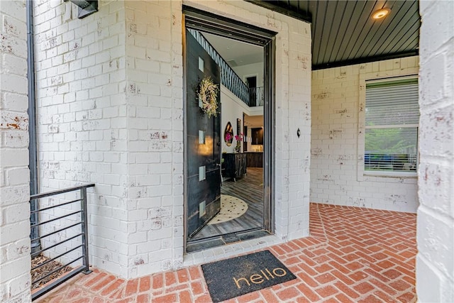 doorway to property featuring brick siding