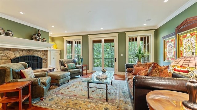 living area featuring wood finished floors, recessed lighting, ornamental molding, a fireplace, and baseboards