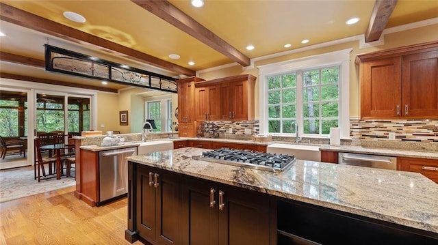 kitchen with stainless steel appliances, a sink, beam ceiling, crown molding, and light wood-style flooring