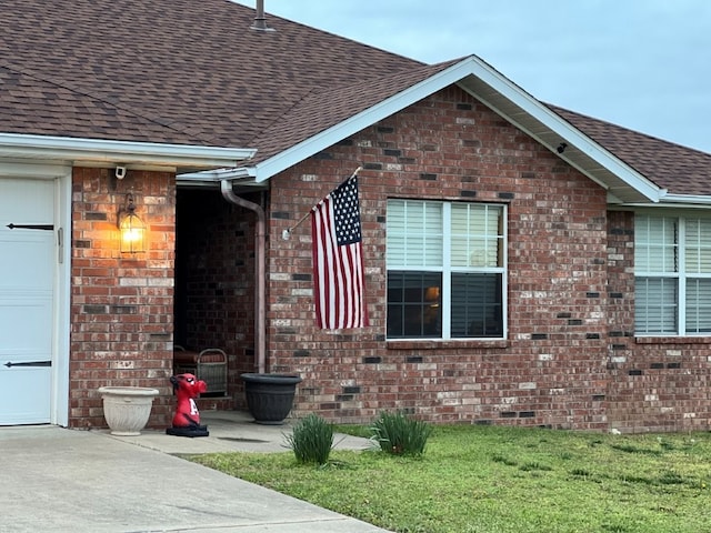 exterior space with brick siding and a shingled roof