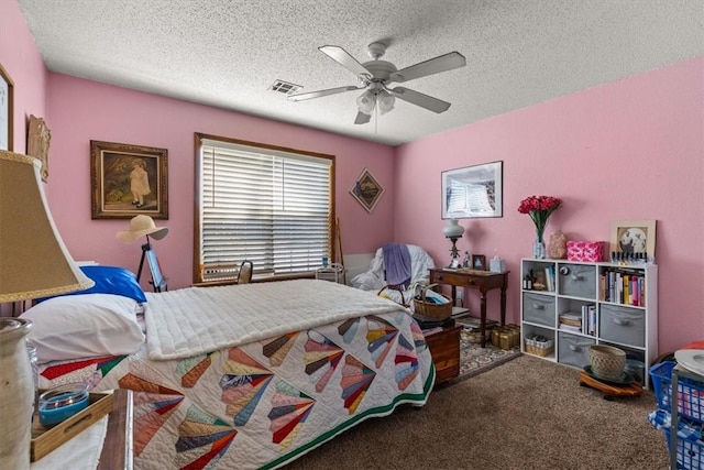 carpeted bedroom featuring visible vents, a textured ceiling, and ceiling fan