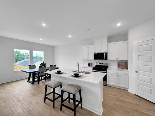 1963 Larkspur St, Springdale, AR 72762 - kitchen featuring stainless steel appliances, light wood-style flooring, white cabinets, and recessed lighting