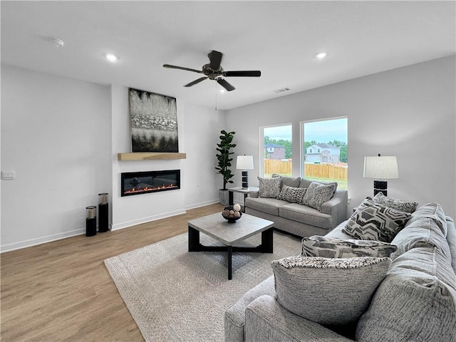1963 Larkspur St, Springdale, AR 72762 - living room with light wood-type flooring, ceiling fan, a glass covered fireplace, and recessed lighting