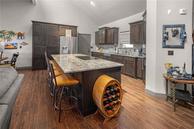 21413 Lakeview Dr, Garfield, AR 72732 - kitchen featuring a kitchen breakfast bar, dark brown cabinets, light stone countertops, appliances with stainless steel finishes, and a sink