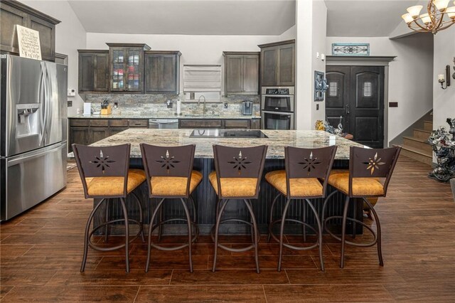 21413 Lakeview Dr, Garfield, AR 72732 - kitchen featuring glass insert cabinets, dark brown cabinetry, dark wood-style flooring, and appliances with stainless steel finishes