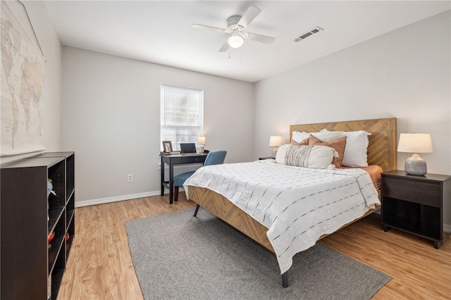 bedroom featuring light wood-style floors, baseboards, a ceiling fan, and visible vents