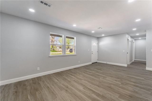 spare room featuring wood finished floors, baseboards, visible vents, and recessed lighting