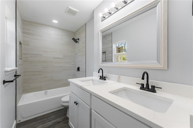 full bathroom featuring visible vents, a sink, toilet, and wood finished floors