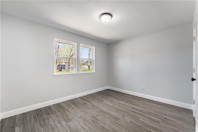 unfurnished room featuring dark wood-style floors and baseboards