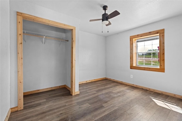 unfurnished bedroom with a closet, baseboards, ceiling fan, and wood finished floors