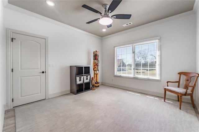 interior space with crown molding, ceiling fan, carpet, visible vents, and baseboards