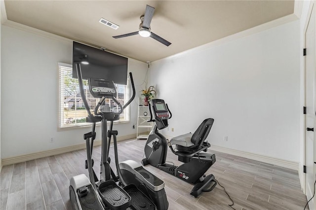 exercise room featuring crown molding, visible vents, ceiling fan, and wood tiled floor