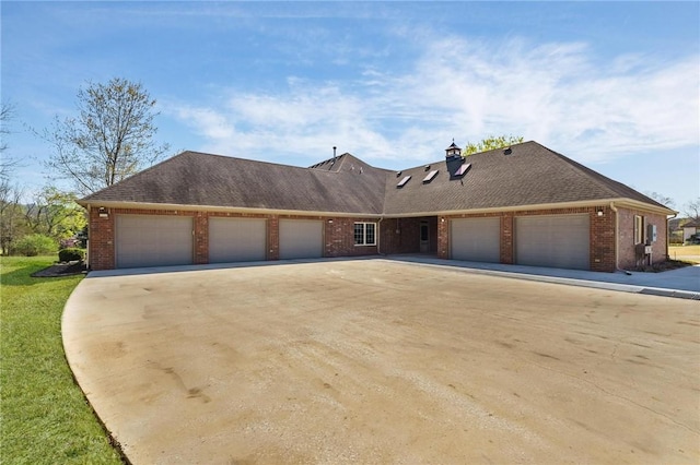view of front of home with an attached garage, a chimney, driveway, and brick siding