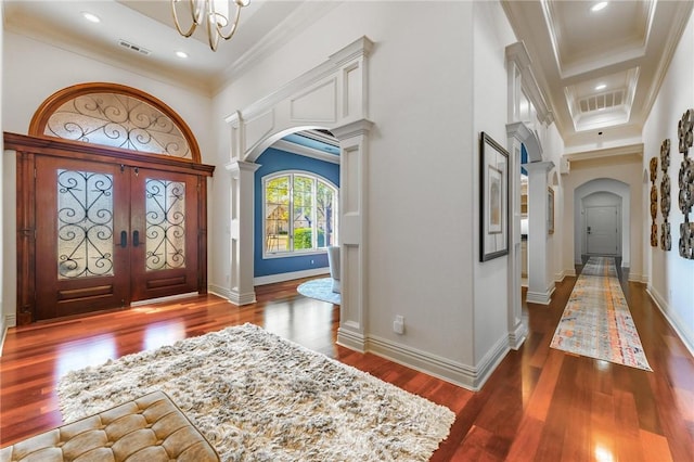 entryway with decorative columns, arched walkways, visible vents, and crown molding