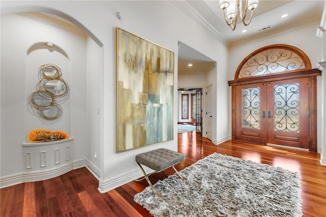 entryway with baseboards, crown molding, and wood finished floors