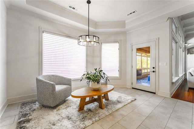 living area featuring a tray ceiling, a chandelier, light tile patterned flooring, and visible vents