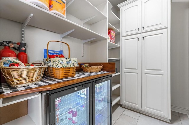 laundry area featuring a bar, light tile patterned floors, and wine cooler