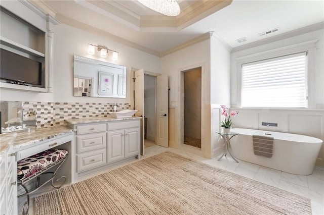 bathroom with a tray ceiling, marble finish floor, ornamental molding, and visible vents
