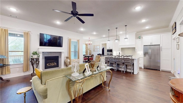 living room featuring recessed lighting, ceiling fan with notable chandelier, dark wood finished floors, and visible vents