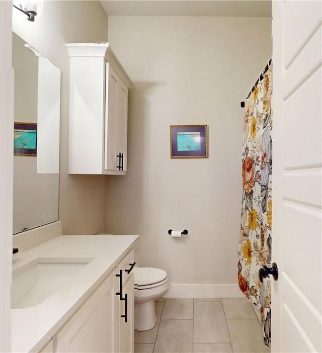 bathroom featuring tile patterned flooring, vanity, toilet, baseboards, and a shower with shower curtain