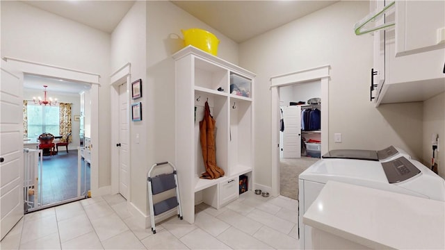 mudroom with light tile patterned floors, baseboards, independent washer and dryer, and a notable chandelier