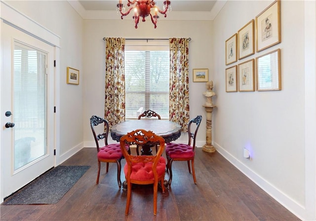 dining room with baseboards, ornamental molding, dark wood-style flooring, and a chandelier