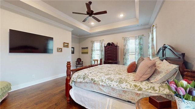 bedroom featuring wood finished floors, a raised ceiling, baseboards, ornamental molding, and recessed lighting