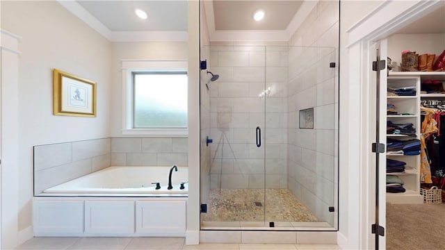 full bathroom with a garden tub, crown molding, a stall shower, and a spacious closet