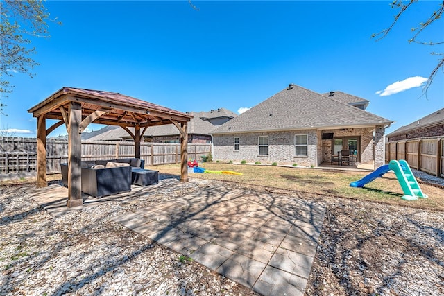 rear view of property featuring an outdoor living space, a gazebo, a patio area, and a fenced backyard