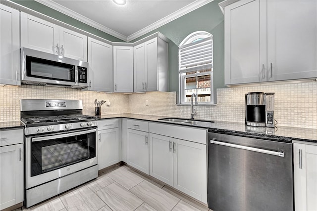 kitchen featuring dark stone countertops, a sink, crown molding, appliances with stainless steel finishes, and decorative backsplash