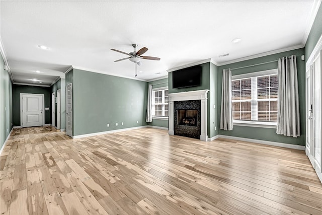 unfurnished living room featuring crown molding, baseboards, ceiling fan, and light wood-style floors