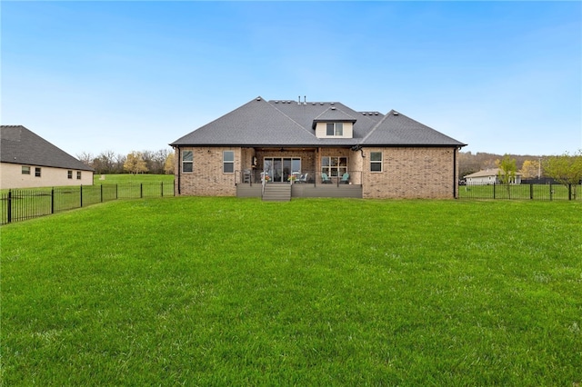 back of house featuring roof with shingles, a yard, brick siding, and a fenced backyard