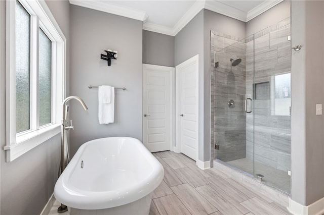 full bath featuring crown molding, a freestanding tub, and a stall shower