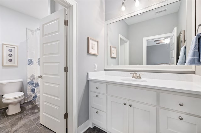 bathroom featuring toilet, vanity, ceiling fan, and visible vents
