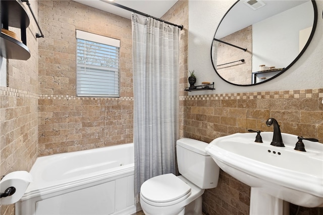 708 NW B St, Bentonville, AR 72712 - bathroom featuring a sink, shower / tub combo with curtain, tile walls, toilet, and visible vents