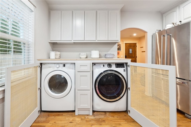 708 NW B St, Bentonville, AR 72712 - laundry room featuring light wood-type flooring, independent washer and dryer, and arched walkways
