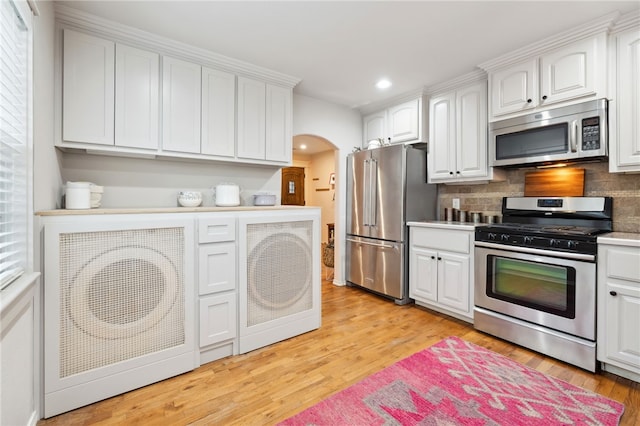 708 NW B St, Bentonville, AR 72712 - kitchen featuring arched walkways, white cabinetry, stainless steel appliances, and recessed lighting