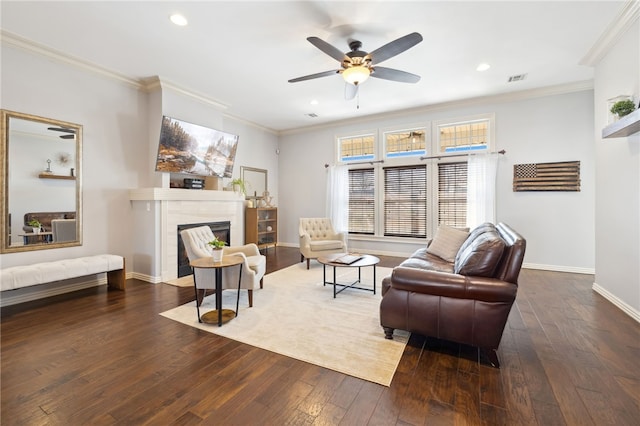 living area with baseboards, ornamental molding, ceiling fan, a fireplace with flush hearth, and hardwood / wood-style floors