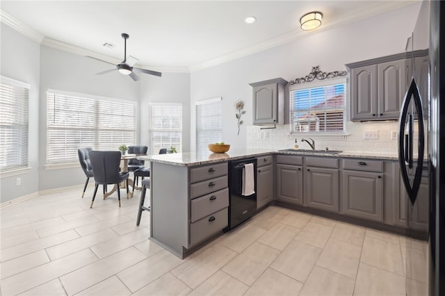 kitchen with a ceiling fan, a sink, a peninsula, black appliances, and gray cabinets