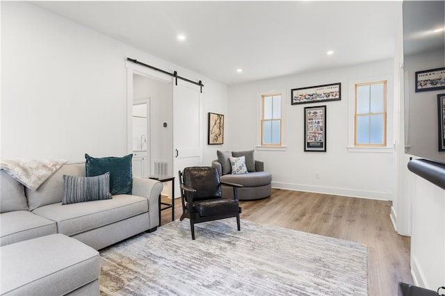 living area featuring baseboards, recessed lighting, a barn door, and wood finished floors