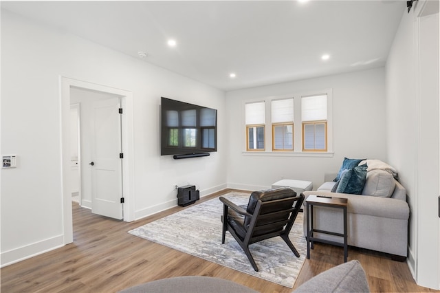 living room featuring wood finished floors, baseboards, and recessed lighting