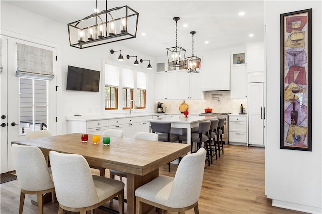 dining room featuring light wood-style flooring, an inviting chandelier, and recessed lighting