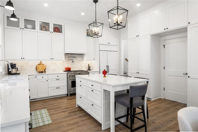 kitchen featuring tasteful backsplash, custom exhaust hood, premium appliances, a sink, and a chandelier