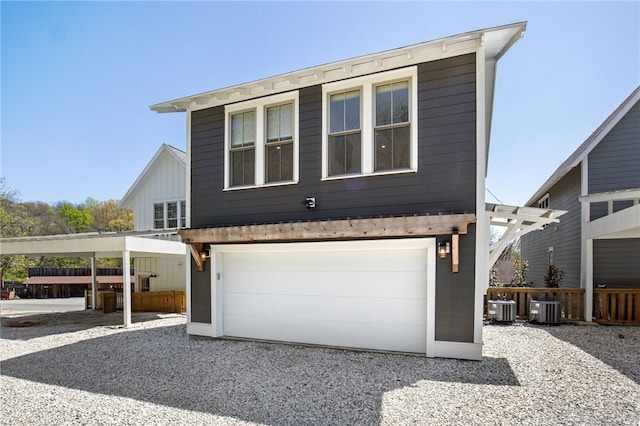 view of front of home with a garage, gravel driveway, central AC, and fence