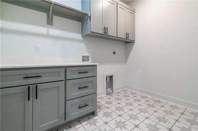 washroom with cabinet space, hookup for an electric dryer, hookup for a washing machine, and baseboards