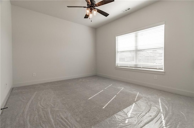 carpeted empty room featuring ceiling fan and baseboards