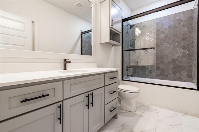 bathroom with enclosed tub / shower combo, toilet, vanity, and marble finish floors