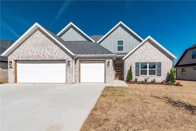 craftsman-style home with board and batten siding, concrete driveway, an attached garage, brick siding, and a front lawn