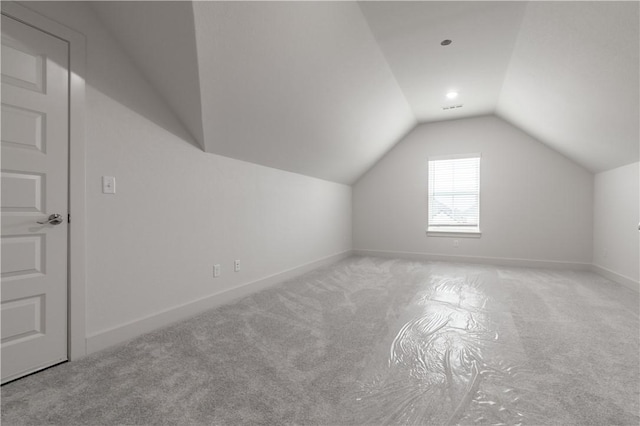 additional living space featuring carpet floors, vaulted ceiling, and baseboards