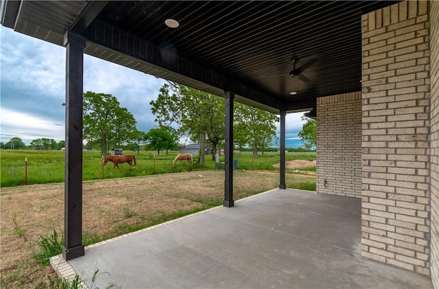 view of patio featuring a view of rural / pastoral area and a ceiling fan